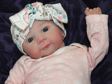 A baby doll resting on a bed beside, creating a cozy and playful scene.